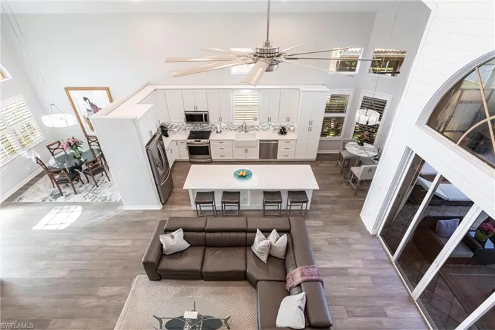 Living room with wood finished floors, a high ceiling, and ceiling fan
