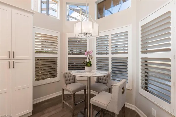 Dining space featuring a chandelier, dark wood finished floors, and a towering ceiling