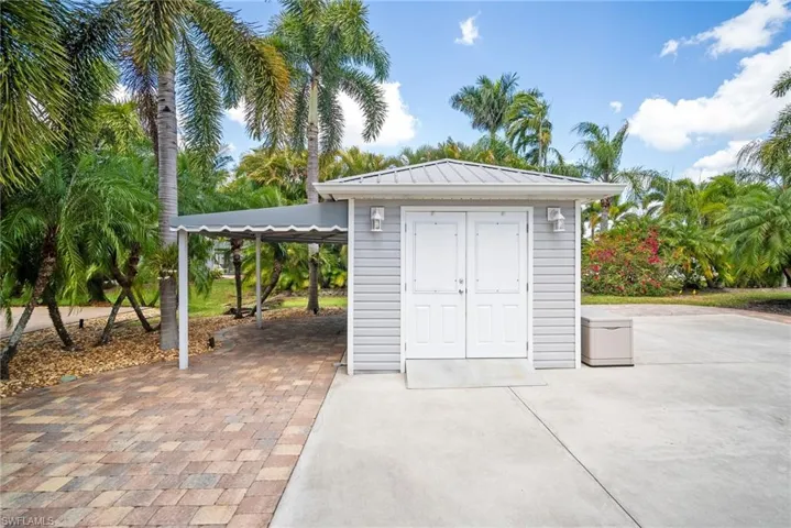 View of shed with an attached carport and driveway
