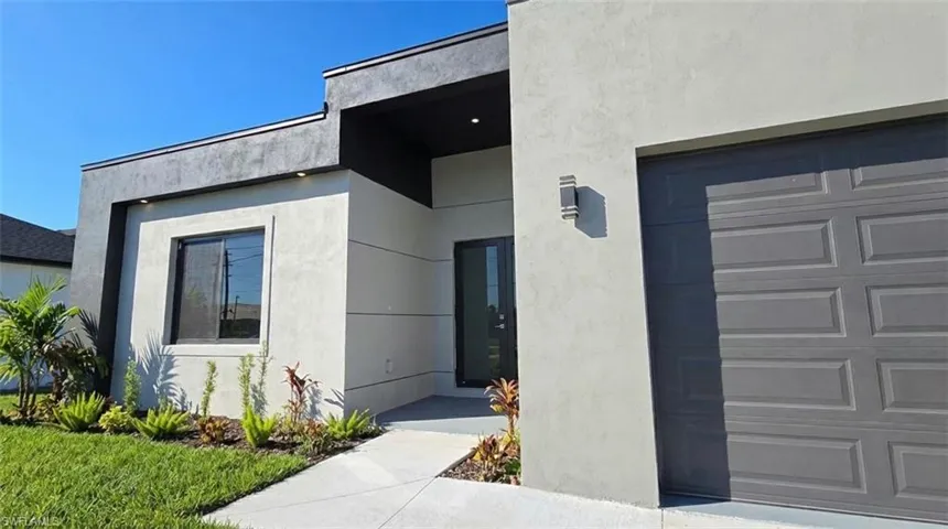 Doorway to property featuring a garage and stucco siding