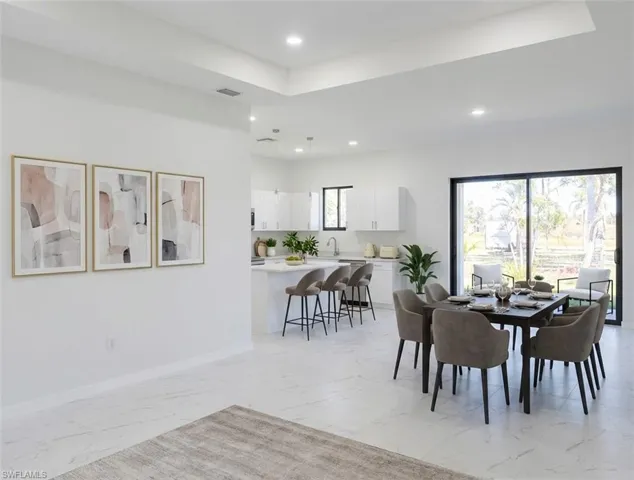 Dining space with a tray ceiling and recessed lighting