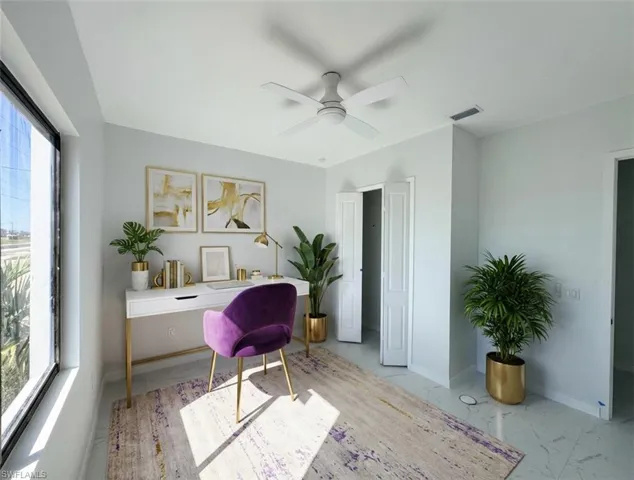 Office area featuring a ceiling fan and light marble finish flooring
