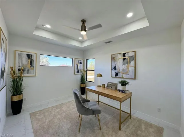 Office area featuring recessed lighting, a ceiling fan, and a raised ceiling