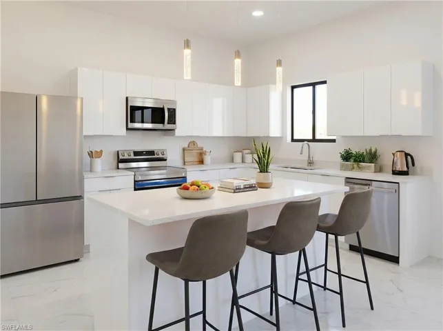 Kitchen with stainless steel appliances, hanging light fixtures, white cabinets, a kitchen island, and a high ceiling