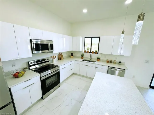 Kitchen featuring stainless steel appliances, white cabinetry, modern cabinets, pendant lighting, and recessed lighting
