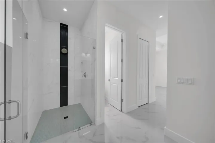 Full bath featuring a marble finish shower, marble tiled floors, and recessed lighting