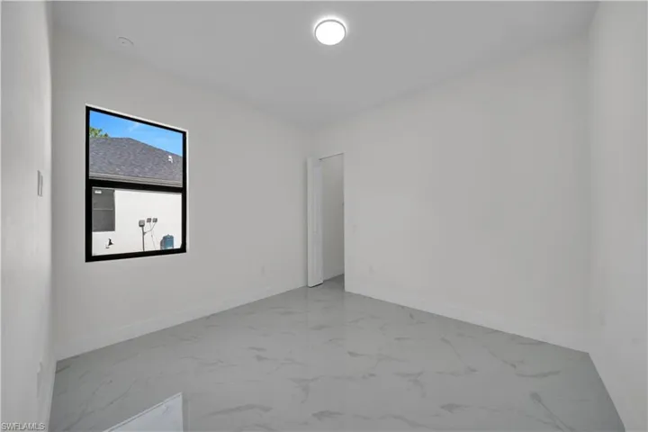 Spare room featuring marble look tile flooring