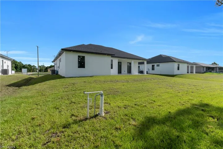 Back of property with stucco siding and a lawn