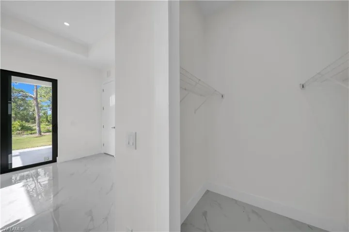 Full bath featuring double vanity, marble finish flooring, and recessed lighting