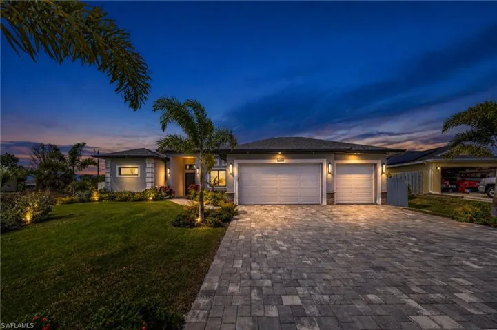 Modern stucco exterior with stone accents and a paver driveway