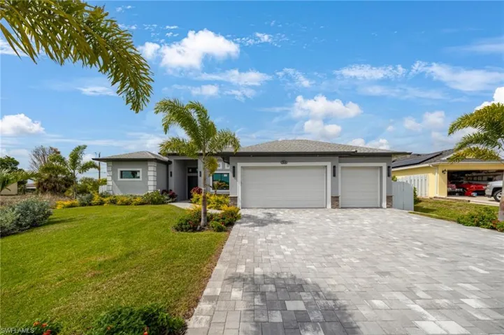 Contemporary architecture featuring a grey stucco exterior with white trim accents and a dark roof