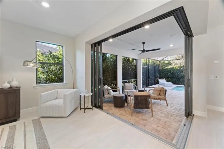 Outdoor pool with a ceiling fan, a lanai, a patio area, and an outdoor living space