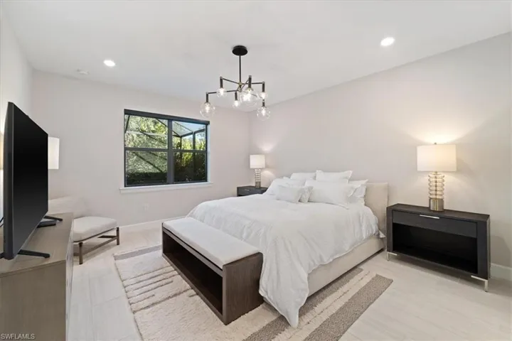 Bedroom with a notable chandelier, light wood finished floors, and baseboards