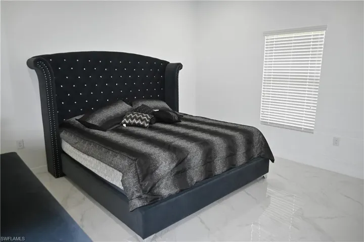 Bedroom featuring light marble finish flooring