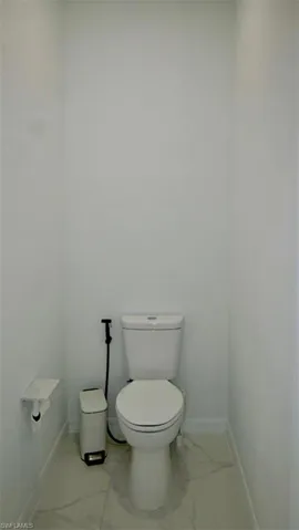 Bathroom featuring baseboards and light marble finish floors