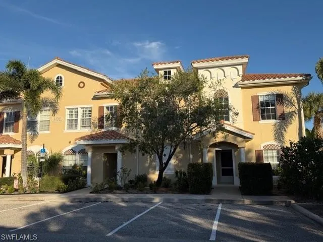 Mediterranean / spanish-style home featuring a tiled roof, stucco siding, and uncovered parking