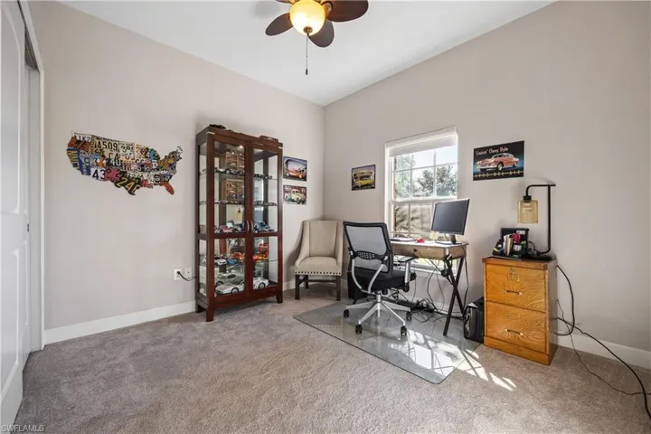 Office space featuring light colored carpet and a ceiling fan