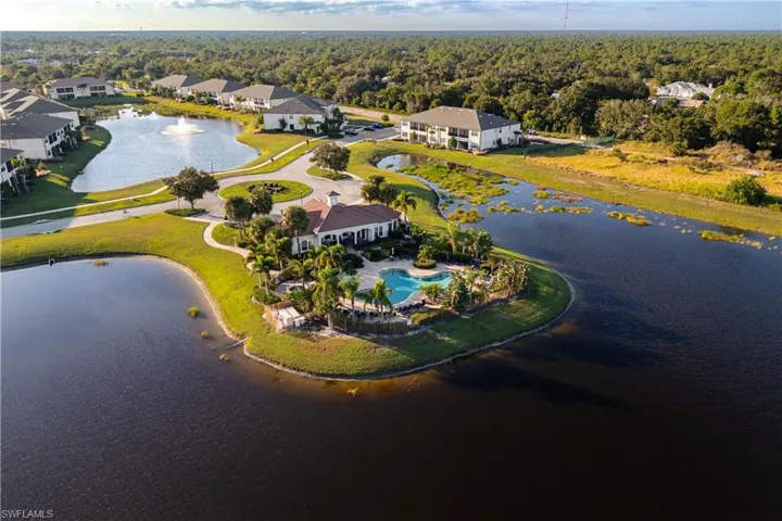 Aerial view of property and surrounding area featuring a nearby body of water and a forest