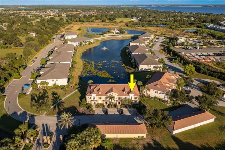 Aerial view of property and surrounding area featuring a nearby body of water and nearby suburban area