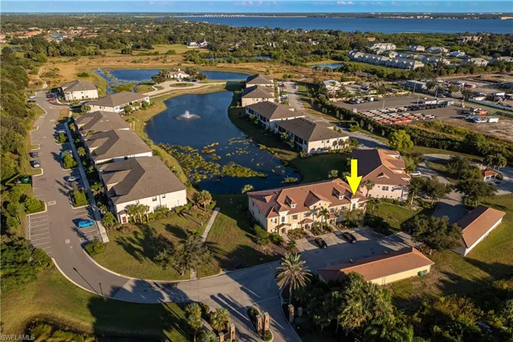 Aerial view of property's location with a nearby body of water and nearby suburban area