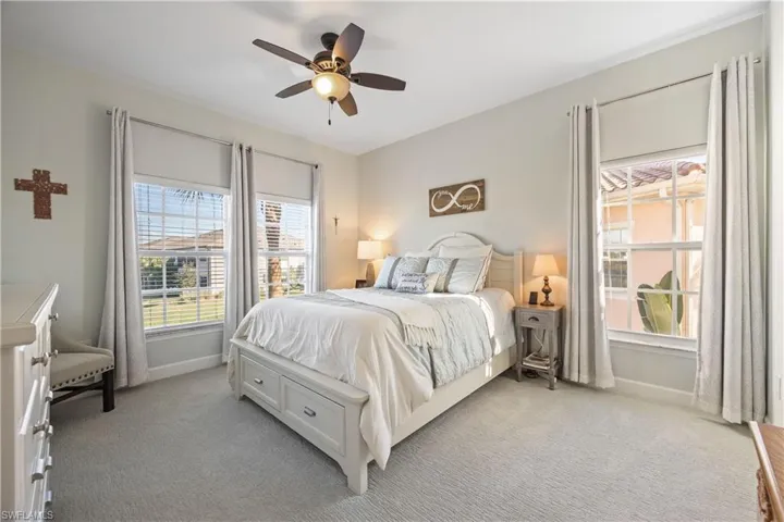 Bedroom with light carpet and a ceiling fan