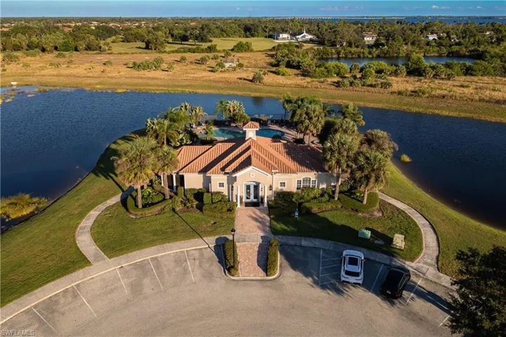 Aerial view of property and surrounding area featuring a nearby body of water and a tree filled landscape