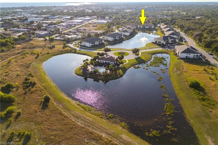Aerial view of property's location featuring a nearby body of water and nearby suburban area