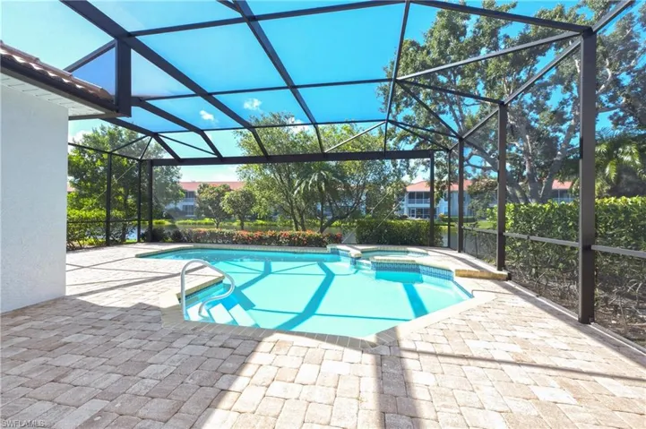 Screened outdoor living area featuring a pool with integrated spa