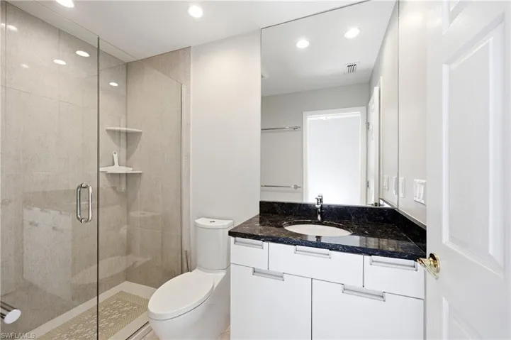 Modern Guest bathroom on first floor featuring a glass-enclosed shower with tiled walls and a built-in shelf