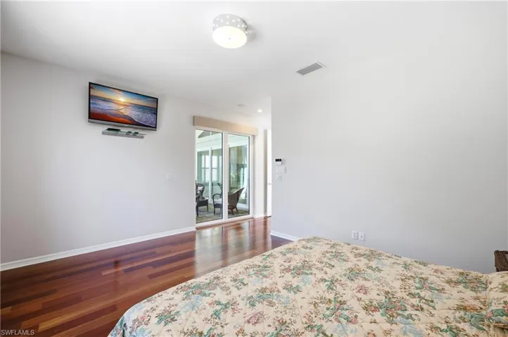 Master Bedroom Hardwood flooring extends throughout this room, complemented by white baseboards and walls