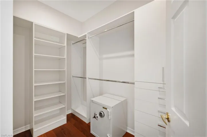 Master Custom closet system featuring built-in shelving, hanging rods, and cabinetry with sleek pulls