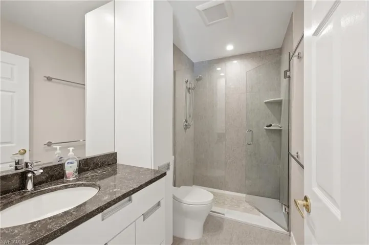 Guest Bathroom on second floor featuring a vanity with a dark stone countertop, undermount sink, and chrome faucet