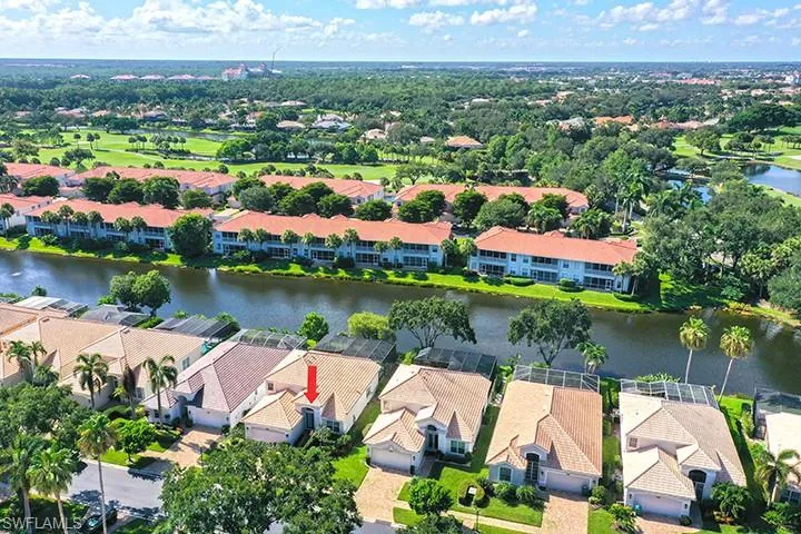 Aerial perspective showcasing a property with a light-colored tile roof and an attached garage