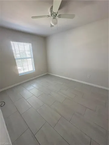 Unfurnished room featuring baseboards and ceiling fan