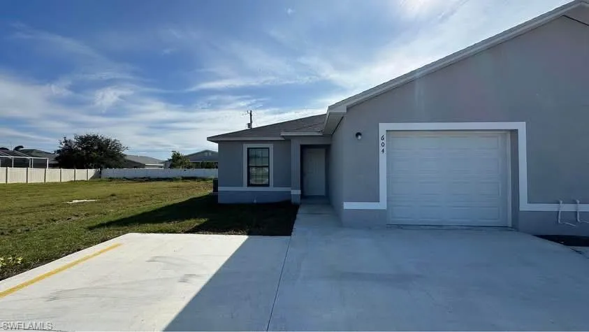 View of front facade featuring stucco siding, a garage, and concrete driveway