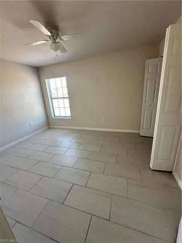 Unfurnished room with baseboards and ceiling fan
