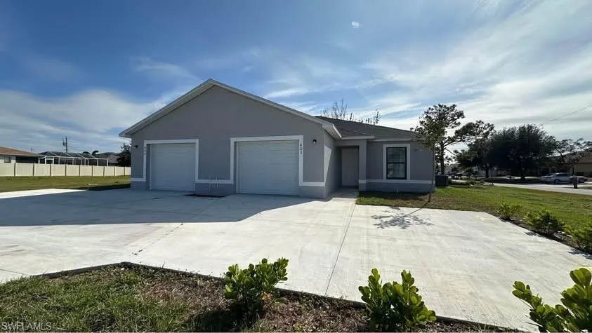 Ranch-style home featuring stucco siding, an attached garage, concrete driveway, and a front lawn
