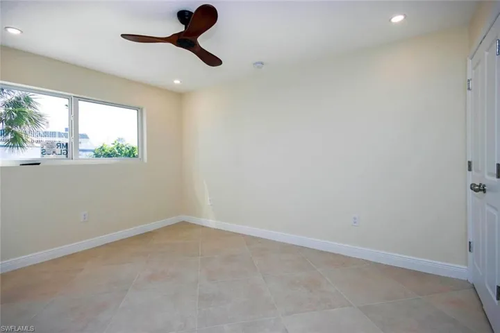 Tiled empty room featuring ceiling fan