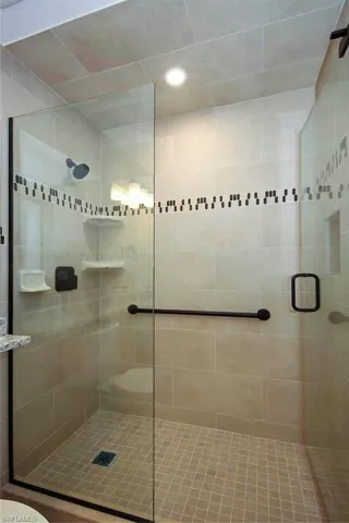 Bathroom featuring a shower with door and toilet