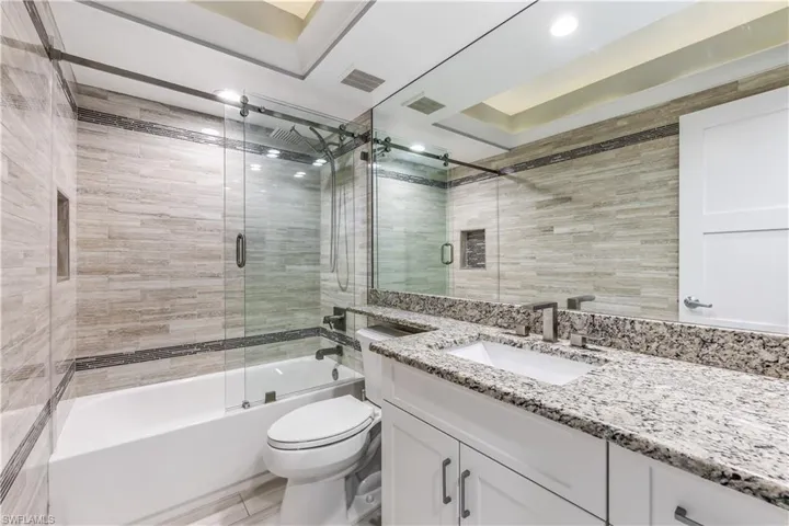 Full bath featuring vanity and shower / bath combination with glass door