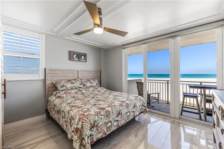 Bedroom with access to exterior, a water view, and a ceiling fan