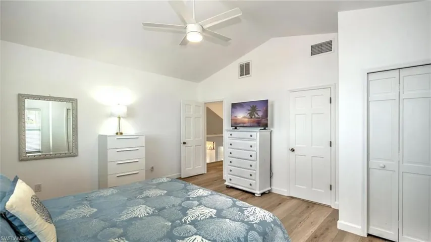 Guest Bedroom upstairs featuring wood finished floors, high vaulted ceiling, and ceiling fanG