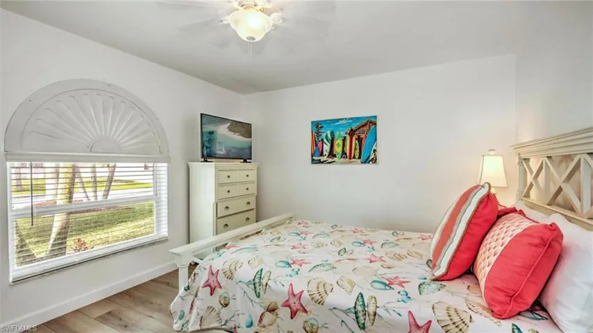 Guest Bedroom downstairs with wood finished floors and ceiling fan