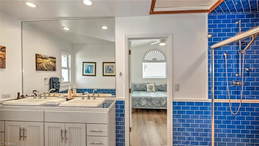 Guest bathroom upstairs with wood finished floors, Jill and Jack bathroom, double vanity, healthy amount of natural light, and recessed lighting