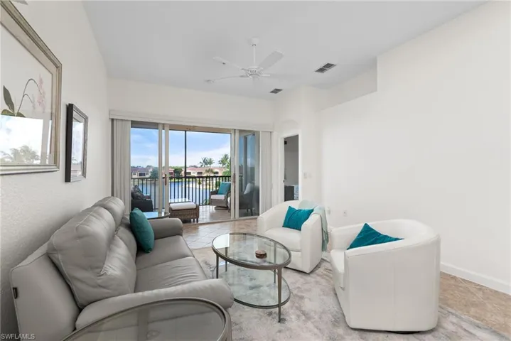 Tiled living room featuring a water view and ceiling fan