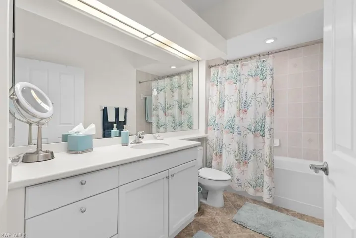 Full bathroom featuring vanity, tile patterned floors, toilet, and shower / bath combination with curtain