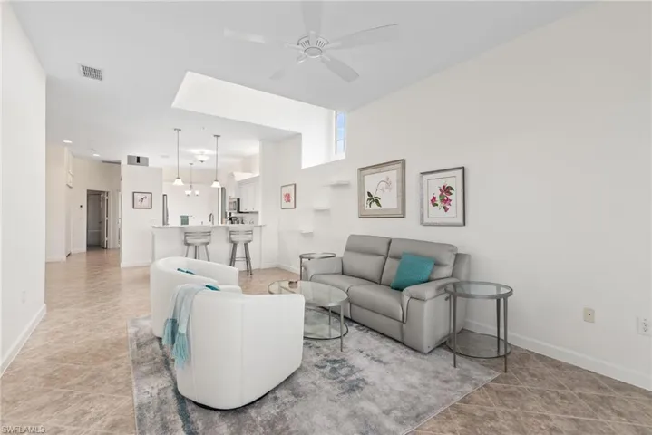 Living room featuring light tile patterned flooring and ceiling fan