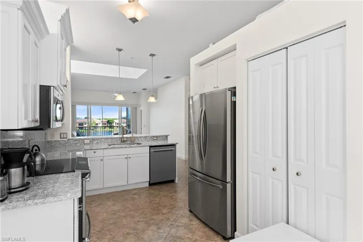 Kitchen with white cabinetry, tasteful backsplash, sink, appliances with stainless steel finishes, and light tile patterned floors