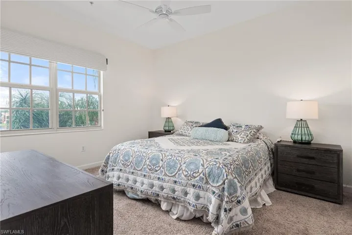 Carpeted bedroom featuring ceiling fan