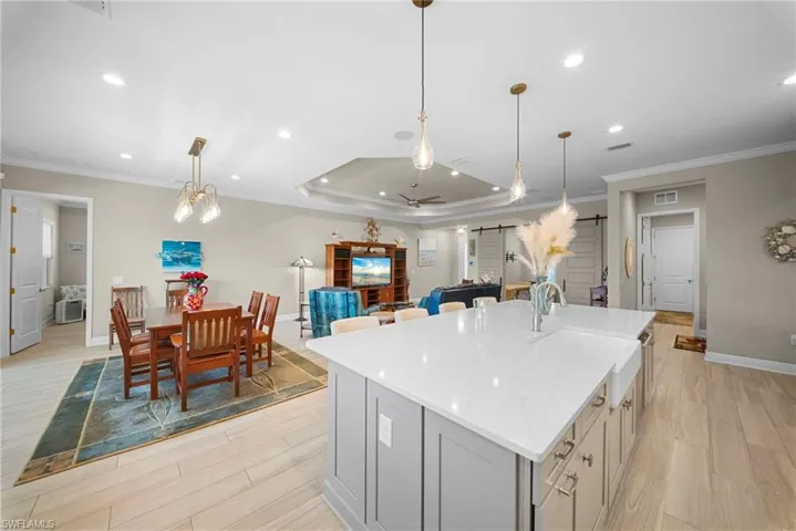 The property features an open-concept living area with light wood flooring and recessed lighting